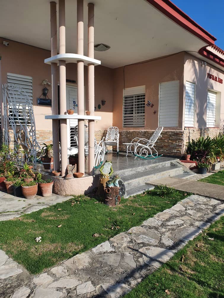 The casa seen from the garden, with rocking chairs on the porch